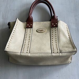 Cream purse with brown leather straps and brass studs